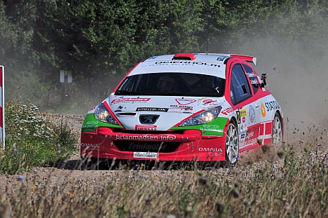 Brian Madsen kører sidelæns sin Peugeot 207 Super 2000 gennem et sving på grusvejen på Antvorskov Kaserne og udbygger føringen i DM i rally